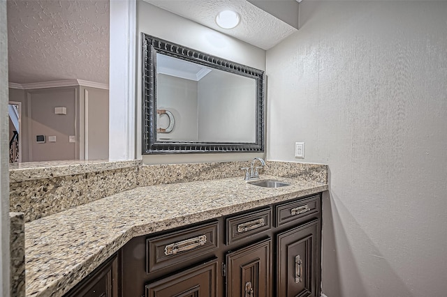 bathroom featuring a textured wall, a textured ceiling, and vanity