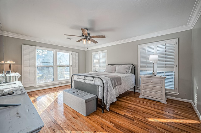 bedroom featuring baseboards, ornamental molding, and wood finished floors