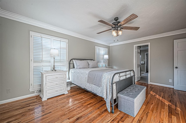 bedroom with baseboards, ornamental molding, ceiling fan, and wood finished floors