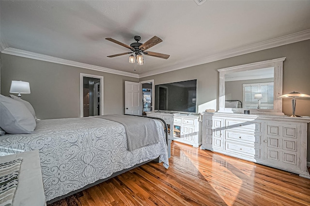 bedroom featuring ceiling fan, ornamental molding, and wood finished floors