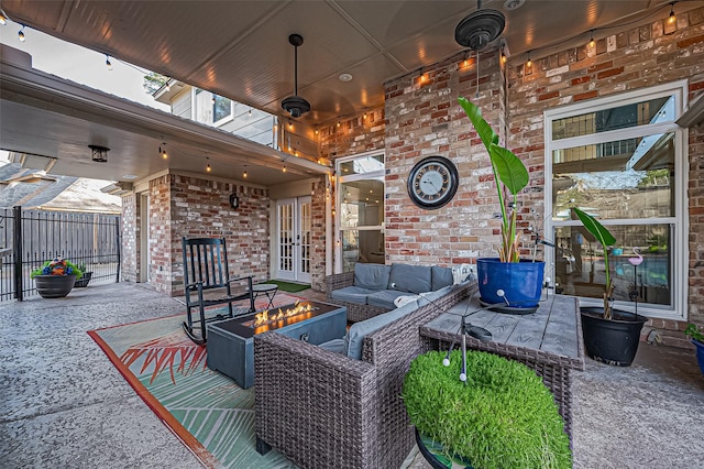 view of patio featuring an outdoor living space with a fire pit, french doors, and fence