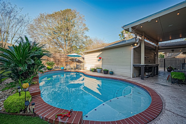 view of swimming pool with a fenced in pool, a fenced backyard, and a patio