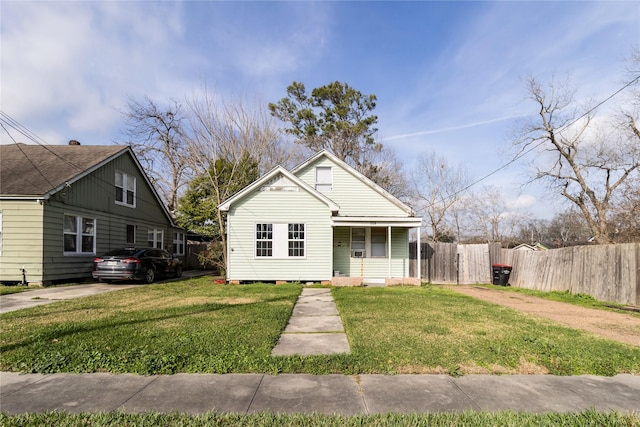 bungalow-style house featuring a front yard, covered porch, and fence