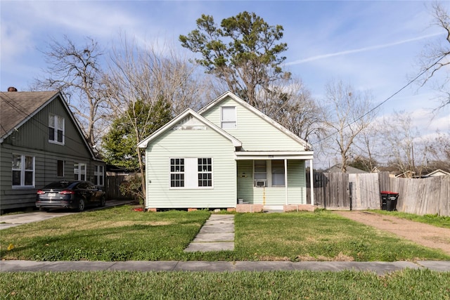 bungalow-style home featuring fence and a front lawn