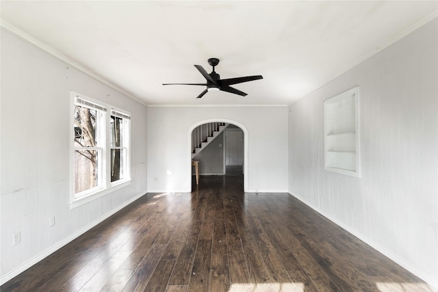 spare room with a ceiling fan, crown molding, arched walkways, and wood finished floors