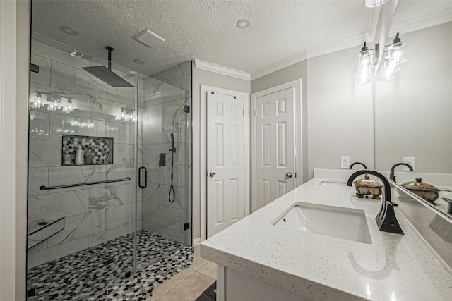 full bath featuring double vanity, ornamental molding, a stall shower, a textured ceiling, and a sink