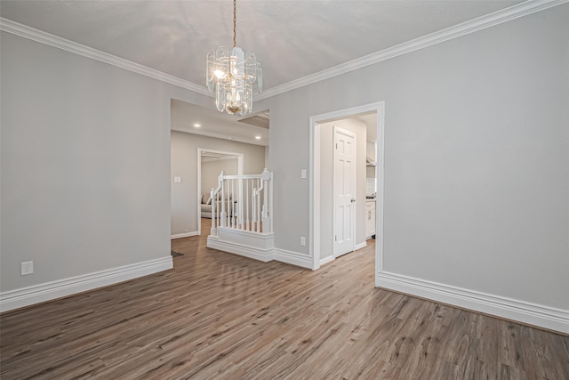 unfurnished dining area featuring baseboards, wood finished floors, stairs, and crown molding
