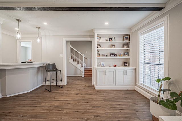 interior space with plenty of natural light, ornamental molding, and dark wood-style flooring