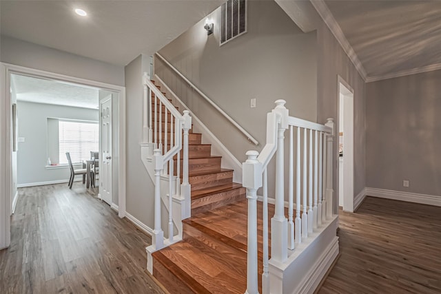 stairway featuring visible vents, baseboards, ornamental molding, recessed lighting, and wood finished floors