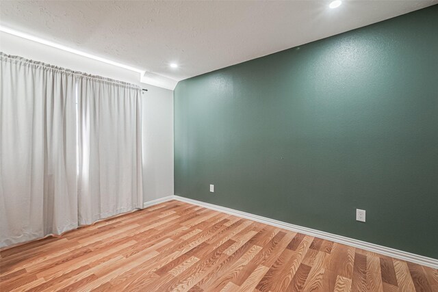 spare room with light wood-style floors and baseboards