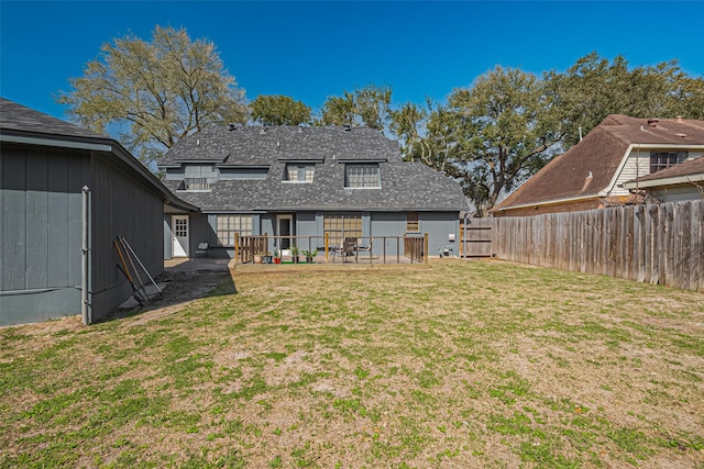 back of property featuring a shingled roof, a patio area, a lawn, and fence private yard