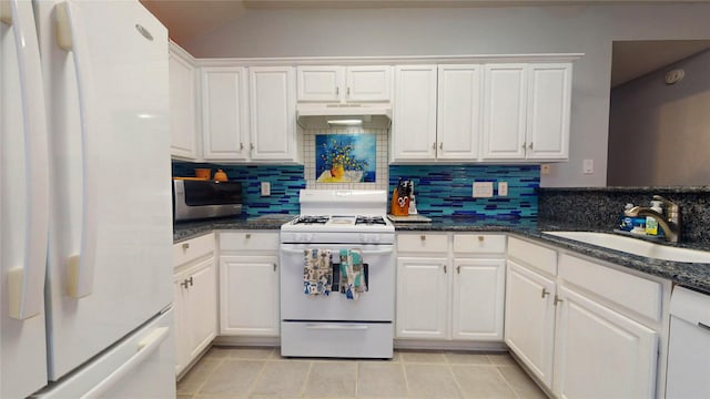 kitchen featuring white appliances, under cabinet range hood, white cabinetry, and a sink