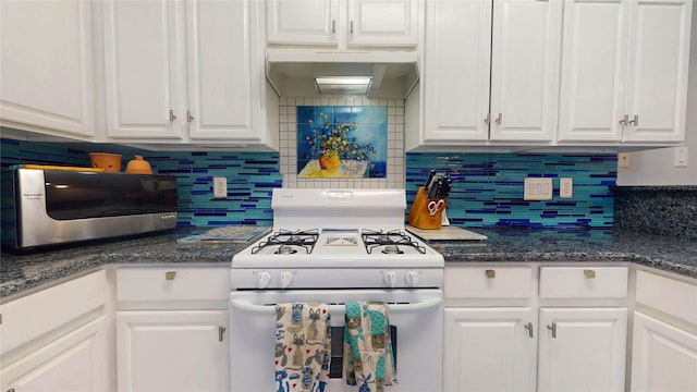 kitchen featuring under cabinet range hood, white cabinets, backsplash, and white gas stove