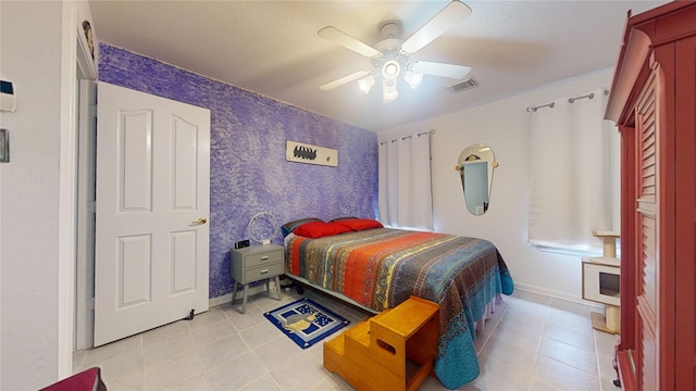 bedroom featuring a ceiling fan, visible vents, baseboards, and light tile patterned floors