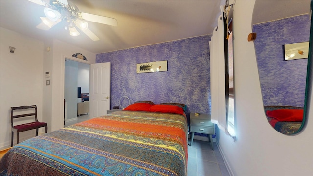 bedroom with a ceiling fan, wallpapered walls, baseboards, and tile patterned floors