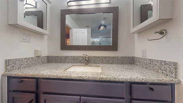 bathroom featuring visible vents, vanity, and walk in shower