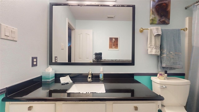 bathroom with toilet, visible vents, a shower with shower curtain, and vanity