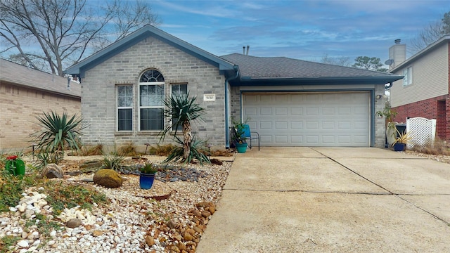 ranch-style home featuring driveway, an attached garage, a shingled roof, and brick siding