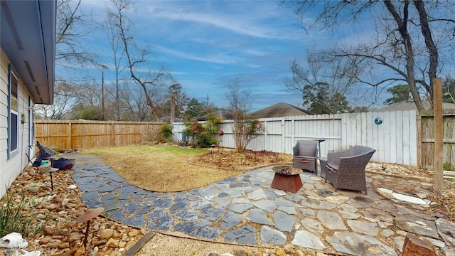 view of patio featuring an outdoor fire pit and a fenced backyard