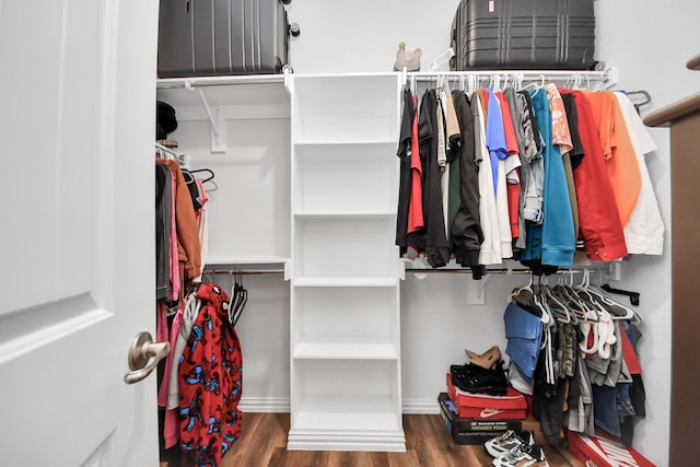 walk in closet with wood finished floors