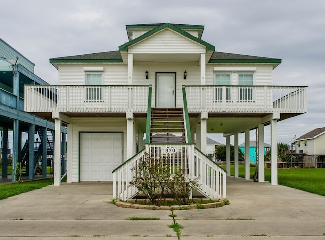 coastal home with an attached garage, a shingled roof, stairs, and a porch