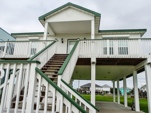 exterior space with a yard, a wooden deck, and stairs