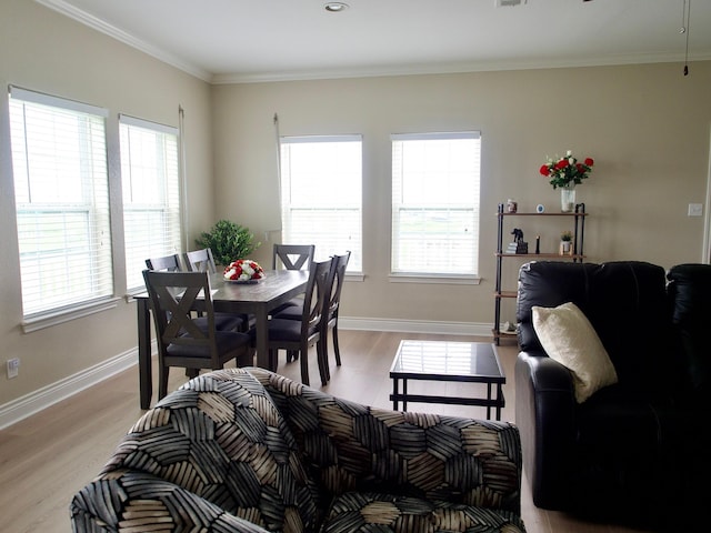 dining space featuring light wood-style flooring, visible vents, baseboards, and crown molding