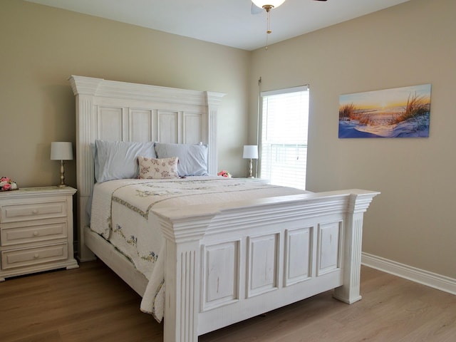 bedroom with wood finished floors, a ceiling fan, and baseboards