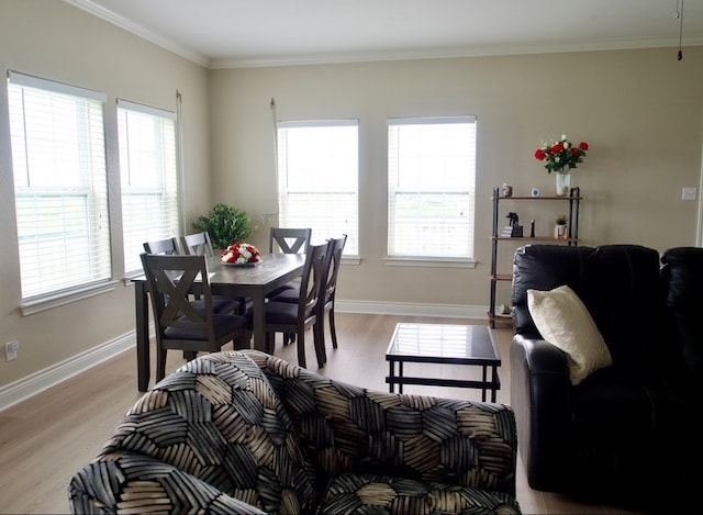 dining space featuring ornamental molding, light wood-type flooring, and baseboards