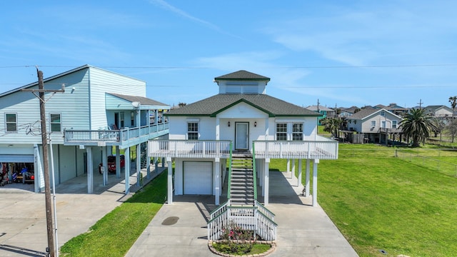 coastal inspired home with stairway, a carport, concrete driveway, a front lawn, and a garage