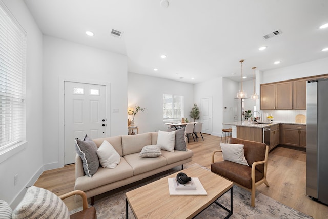 living area featuring light wood-style flooring, recessed lighting, and visible vents