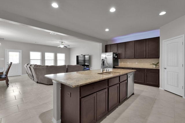 kitchen featuring recessed lighting, a sink, dark brown cabinets, appliances with stainless steel finishes, and backsplash