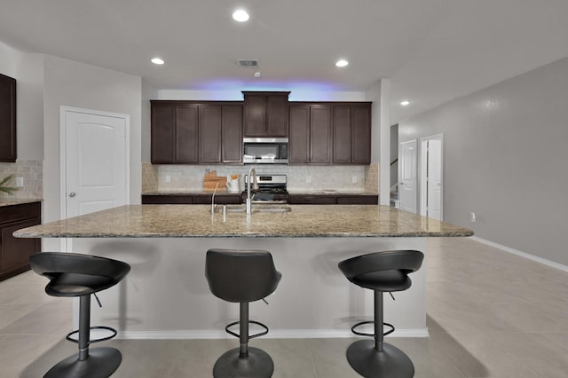 kitchen featuring a sink, visible vents, a kitchen breakfast bar, and appliances with stainless steel finishes