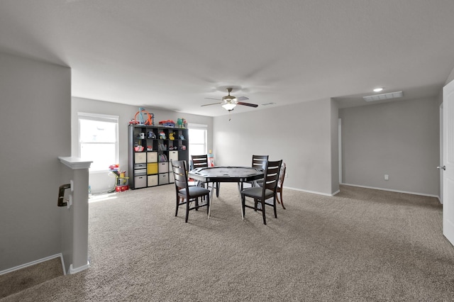 carpeted dining space with a ceiling fan, baseboards, and visible vents