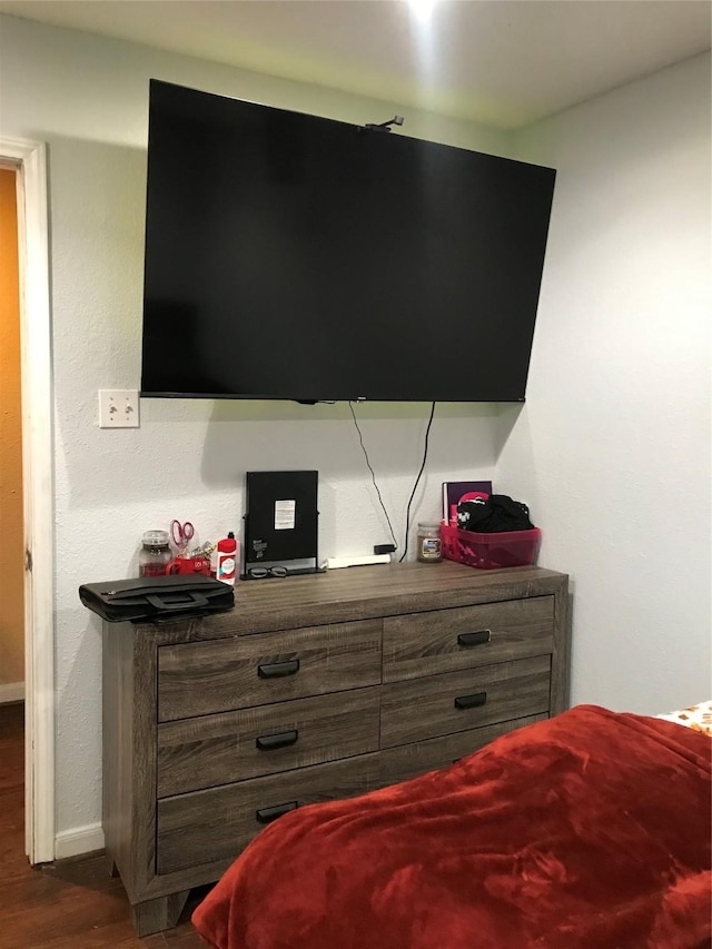 bedroom with baseboards and dark wood-style flooring