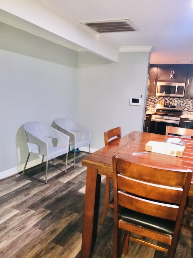 dining area with dark wood-style floors, visible vents, ornamental molding, and baseboards