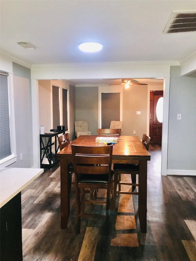 dining space featuring dark wood-style floors, baseboards, visible vents, and crown molding