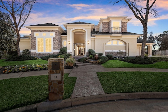 view of front of house with stone siding, stucco siding, and a balcony