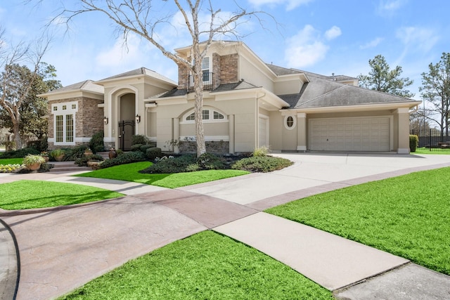 view of front of house with a front lawn, concrete driveway, stucco siding, stone siding, and an attached garage