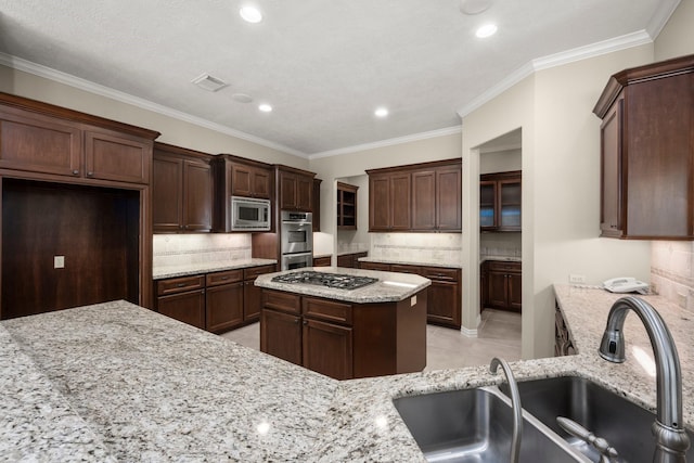 kitchen with light stone counters, light tile patterned floors, visible vents, a sink, and appliances with stainless steel finishes