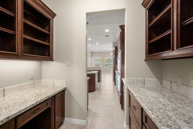 kitchen featuring light stone counters, white oven, dark brown cabinets, and recessed lighting