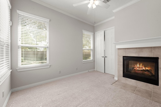 unfurnished living room with a fireplace, carpet flooring, crown molding, baseboards, and ceiling fan