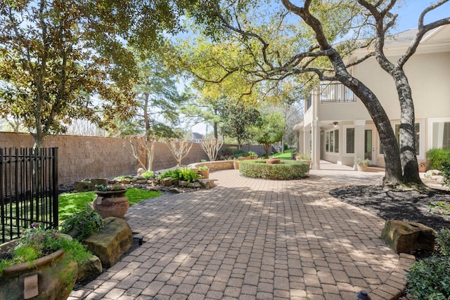 view of patio / terrace with a balcony, french doors, and a fenced backyard