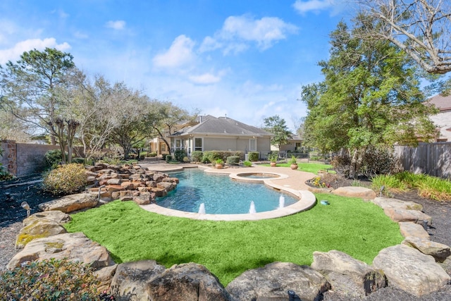 view of pool featuring a yard, an in ground hot tub, and a fenced backyard