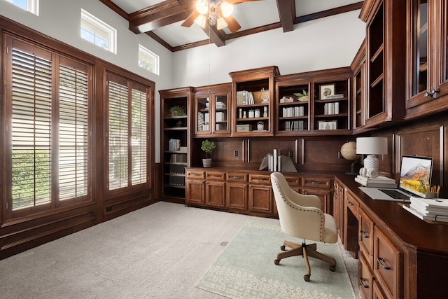 office with beamed ceiling, light carpet, crown molding, ceiling fan, and built in study area