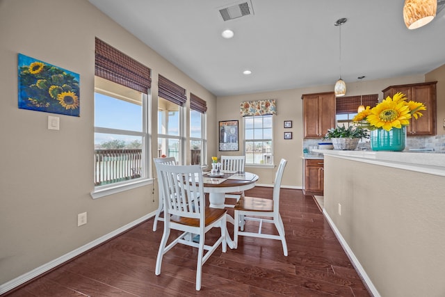 dining room featuring dark wood-style flooring, visible vents, and baseboards