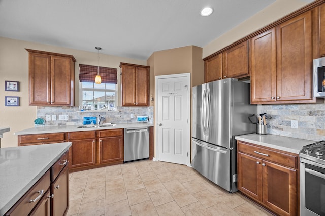 kitchen featuring appliances with stainless steel finishes, brown cabinetry, and a sink