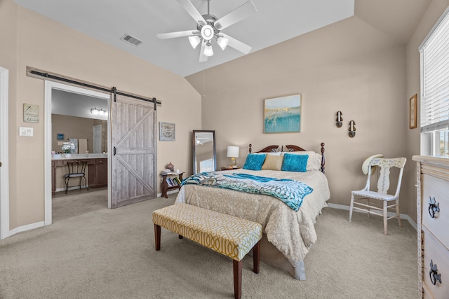 bedroom featuring carpet, visible vents, lofted ceiling, and a barn door