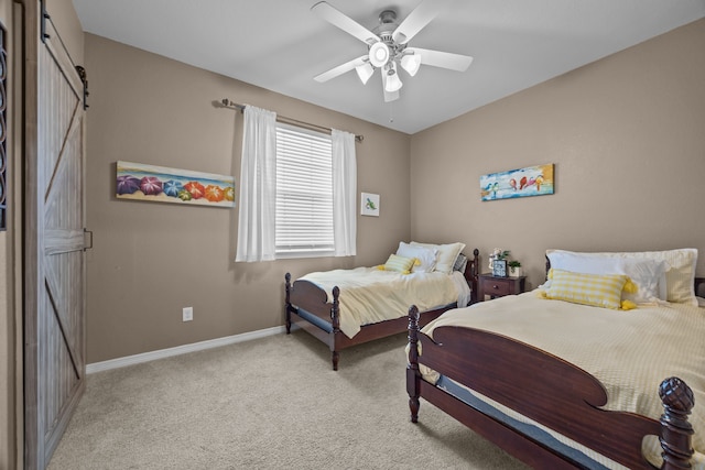 bedroom featuring carpet flooring, ceiling fan, baseboards, and a barn door