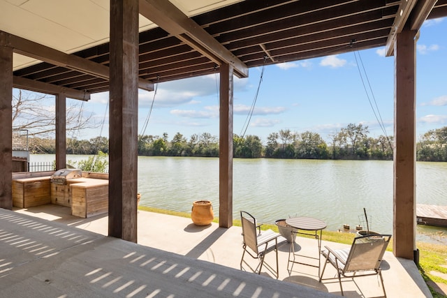 view of patio with an outdoor kitchen, a grill, and a water view